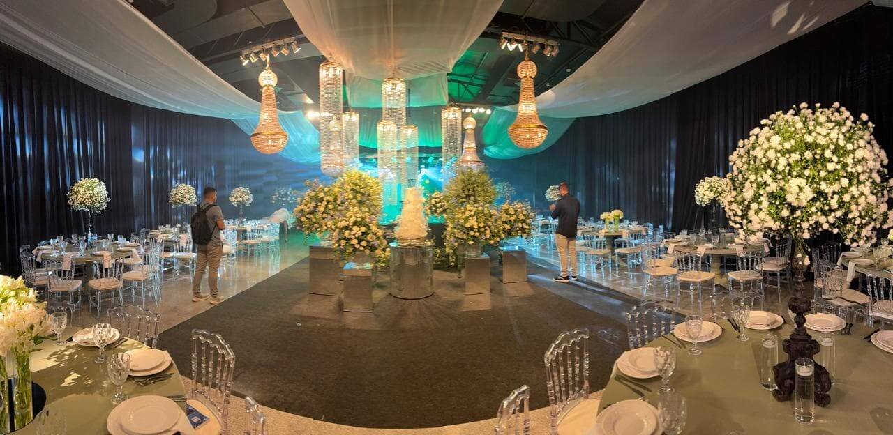Salão de festas de luxo decorado com lustres de cristal, destacando os 17 anos de experiência da DVP Som e Luz em eventos em Rondonópolis.