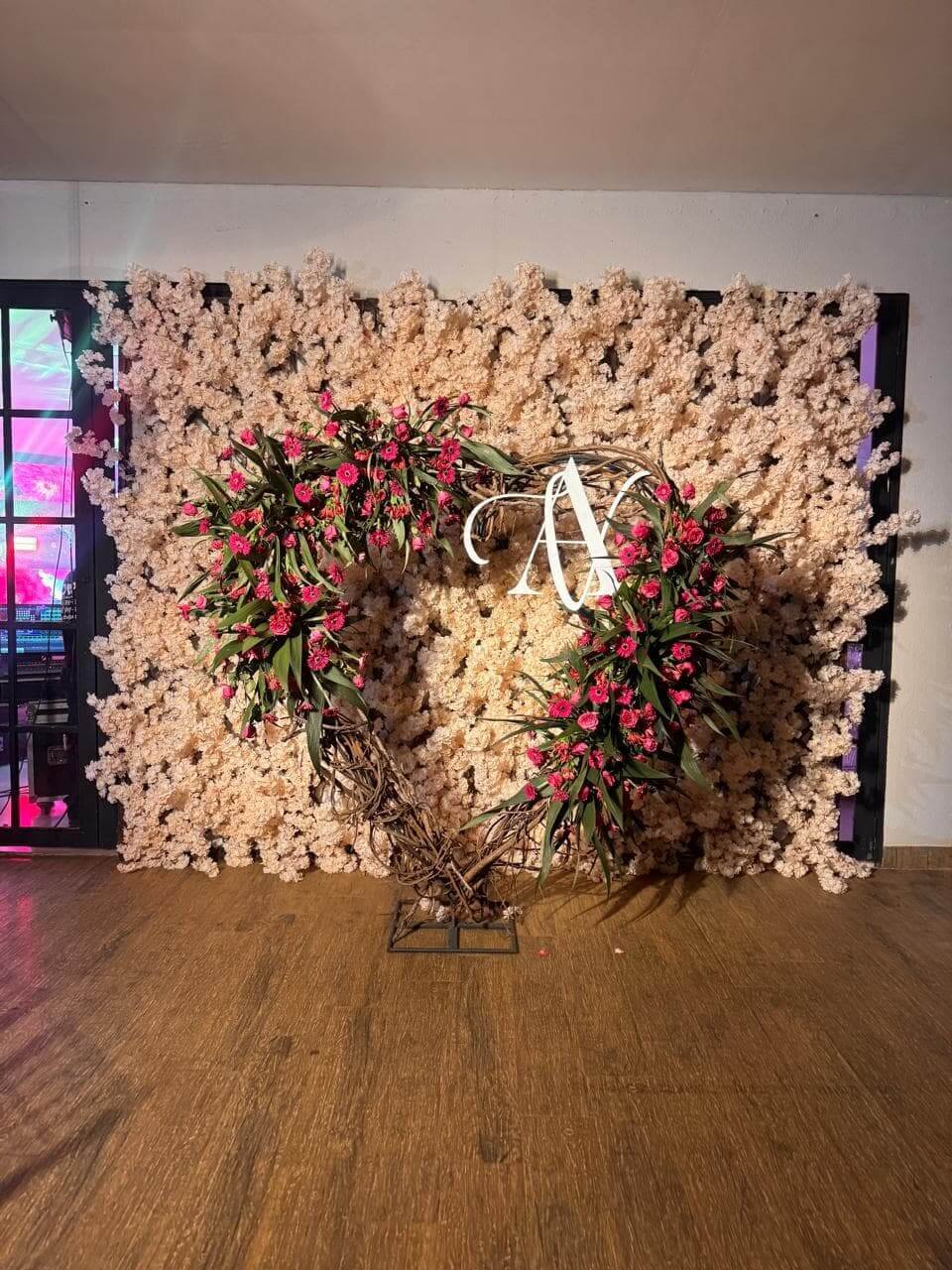 Espaço 'instagramável' para fotos com parede de flores claras e grande coração decorado com rosas para festas e 15 anos.